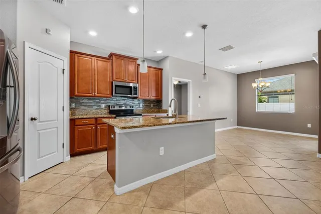 a kitchen with stainless steel appliances granite countertop a refrigerator a oven a sink a oven and a refrigerator