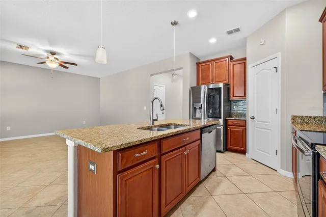 a kitchen with stainless steel appliances granite countertop a sink and a refrigerator