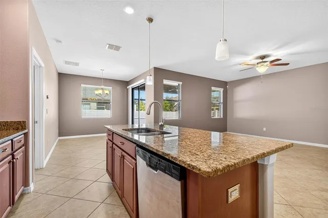 a kitchen with granite countertop kitchen island stainless steel appliances a sink stove and kitchen island