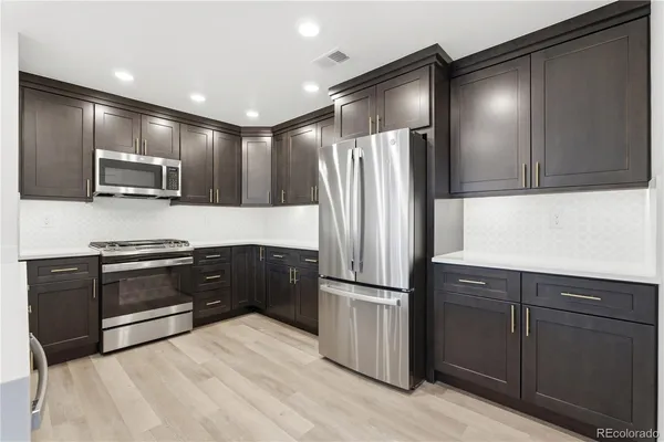 a kitchen with granite countertop stainless steel appliances and refrigerator