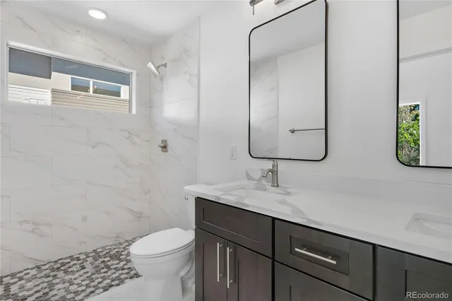 a bathroom with a sink a toilet and shower