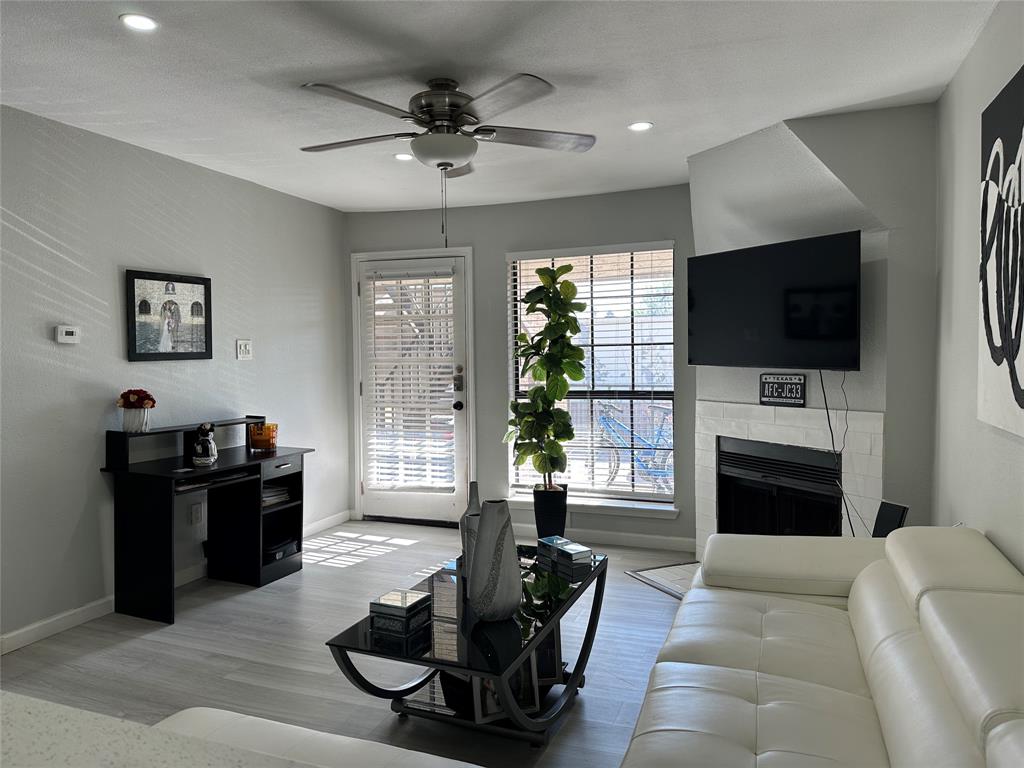 Living area with a fireplace, ceiling fan