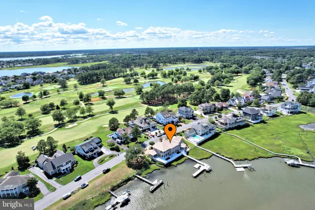 a living room with couches and kitchen view with wooden floor