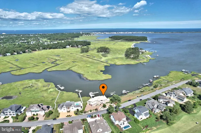 a kitchen with stainless steel appliances granite countertop a stove top oven a sink a dining table and chairs with wooden floor