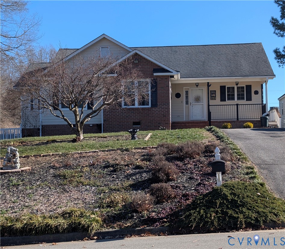 View of front of property with covered porch, bric