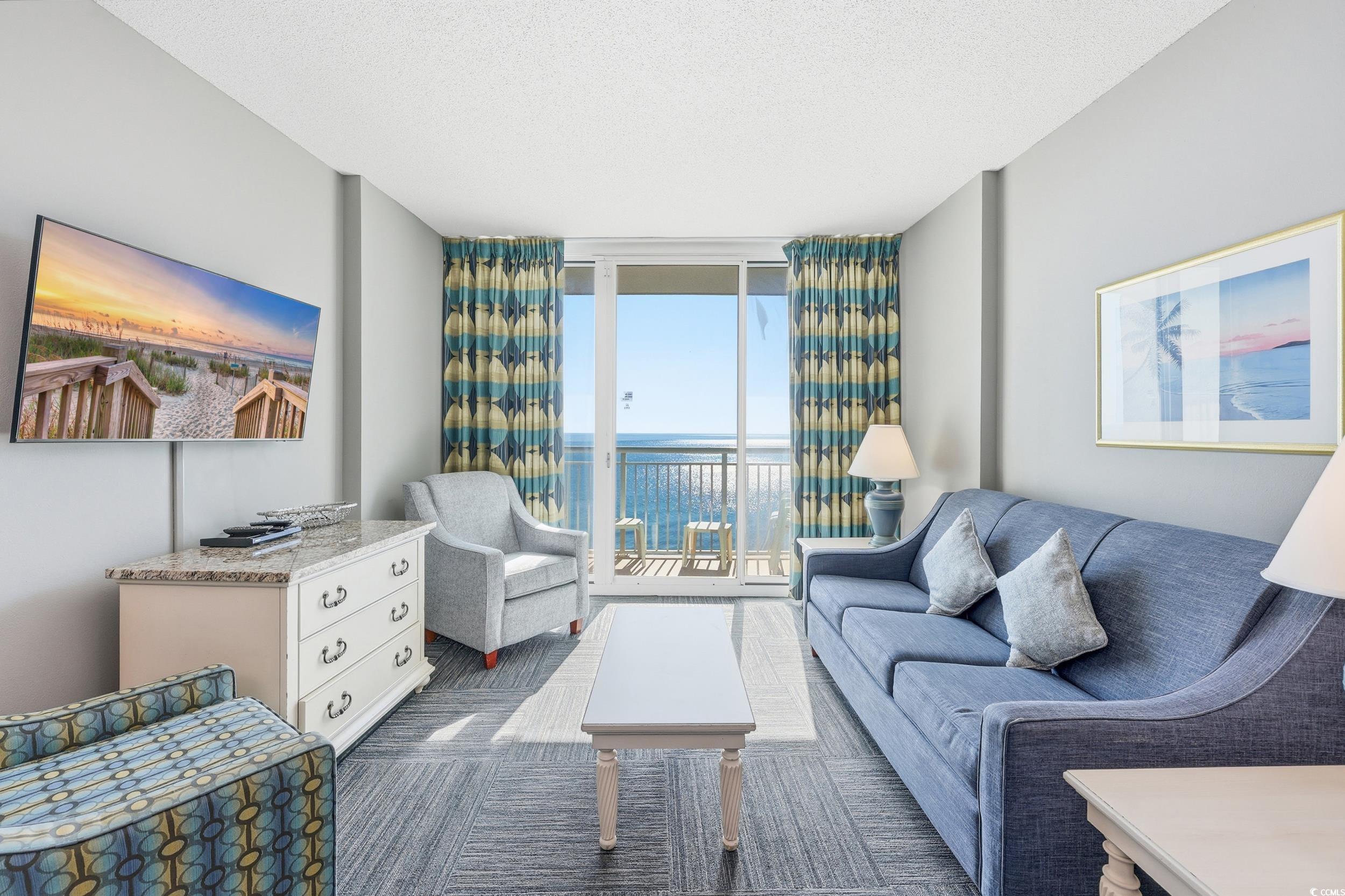 300 North Ocean Boulevard, Unit 1608 North Myrtle Beach, SC 29582 - Photo 11 of 30 Living area with a wall of windows, a textured ceiling, dark carpet, and a water view
