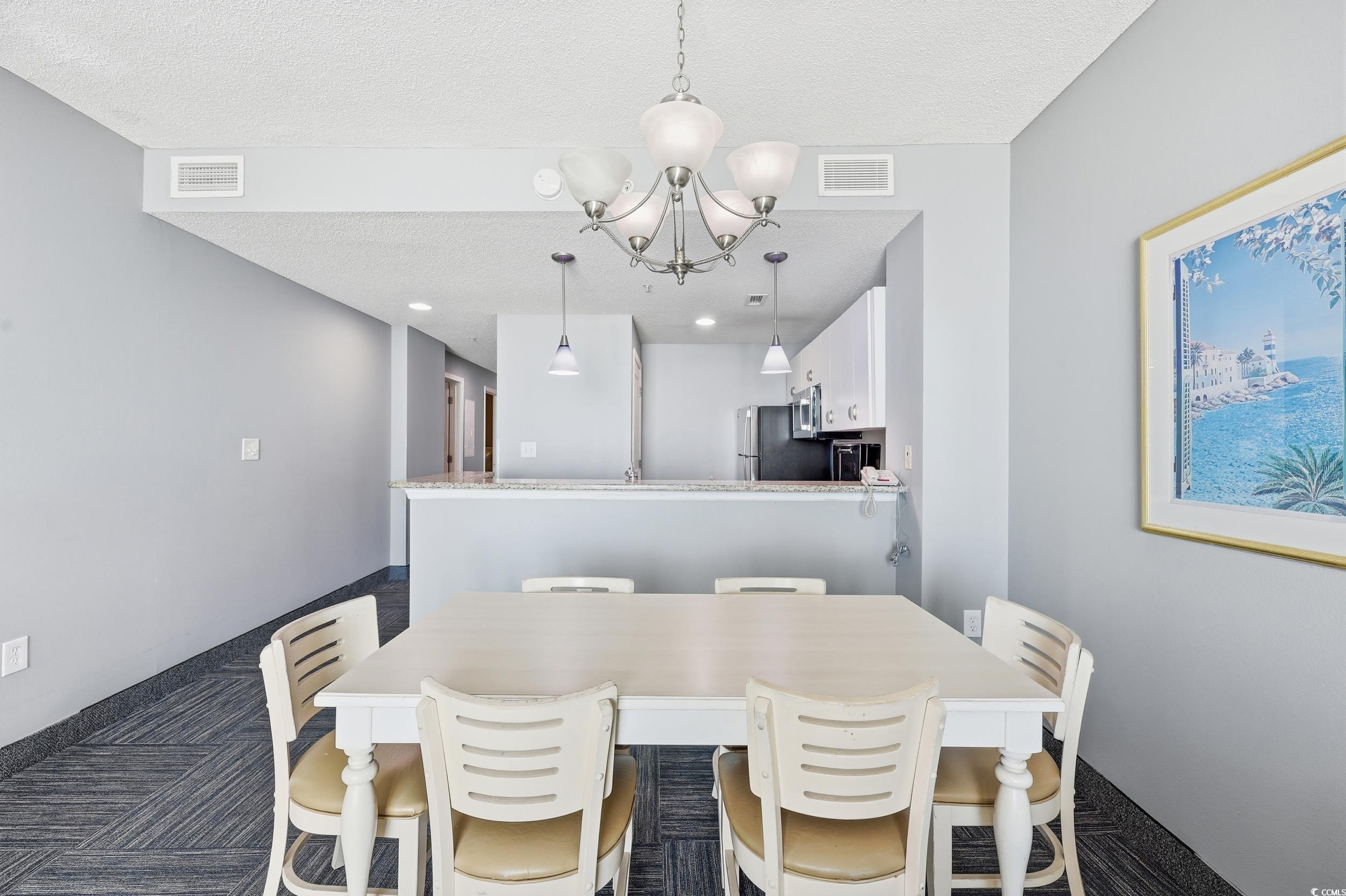 300 North Ocean Boulevard, Unit 1608 North Myrtle Beach, SC 29582 - Photo 12 of 30 Dining space featuring a chandelier, a textured ceiling, recessed lighting, and dark colored carpet
