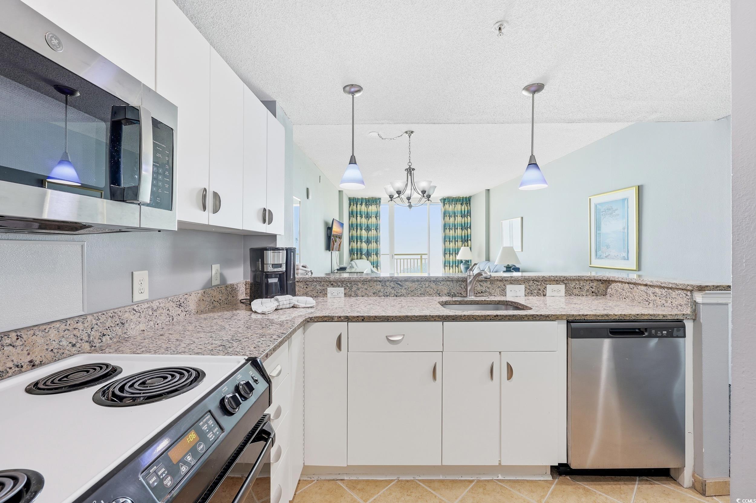 300 North Ocean Boulevard, Unit 1608 North Myrtle Beach, SC 29582 - Photo 13 of 30 Kitchen with white cabinetry, appliances with stainless steel finishes, decorative light fixtures, a chandelier, and light tile patterned floors