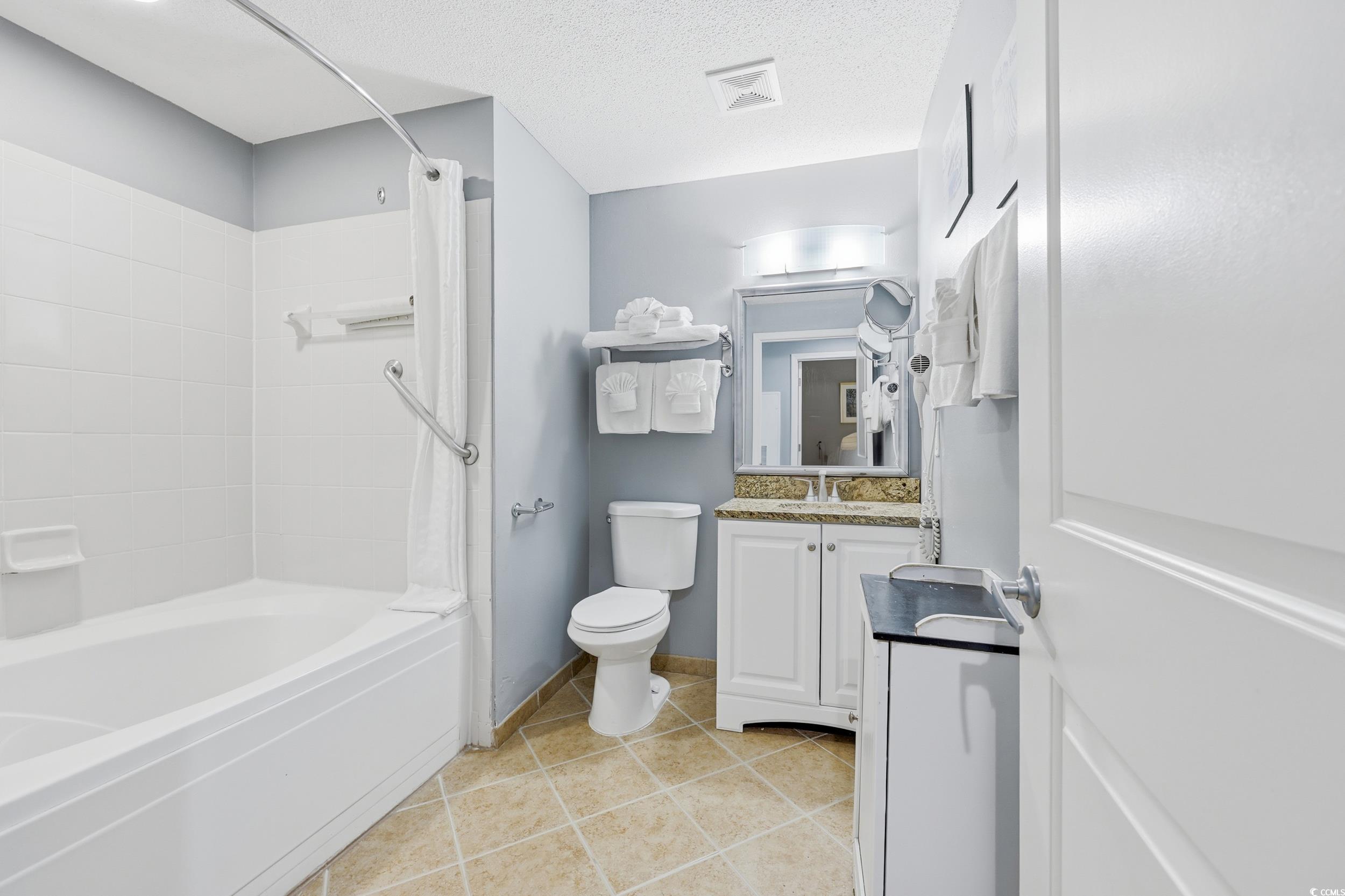 300 North Ocean Boulevard, Unit 1608 North Myrtle Beach, SC 29582 - Photo 18 of 30 Bathroom with vanity, light tile patterned floors, shower / bath combination with curtain, and a textured ceiling