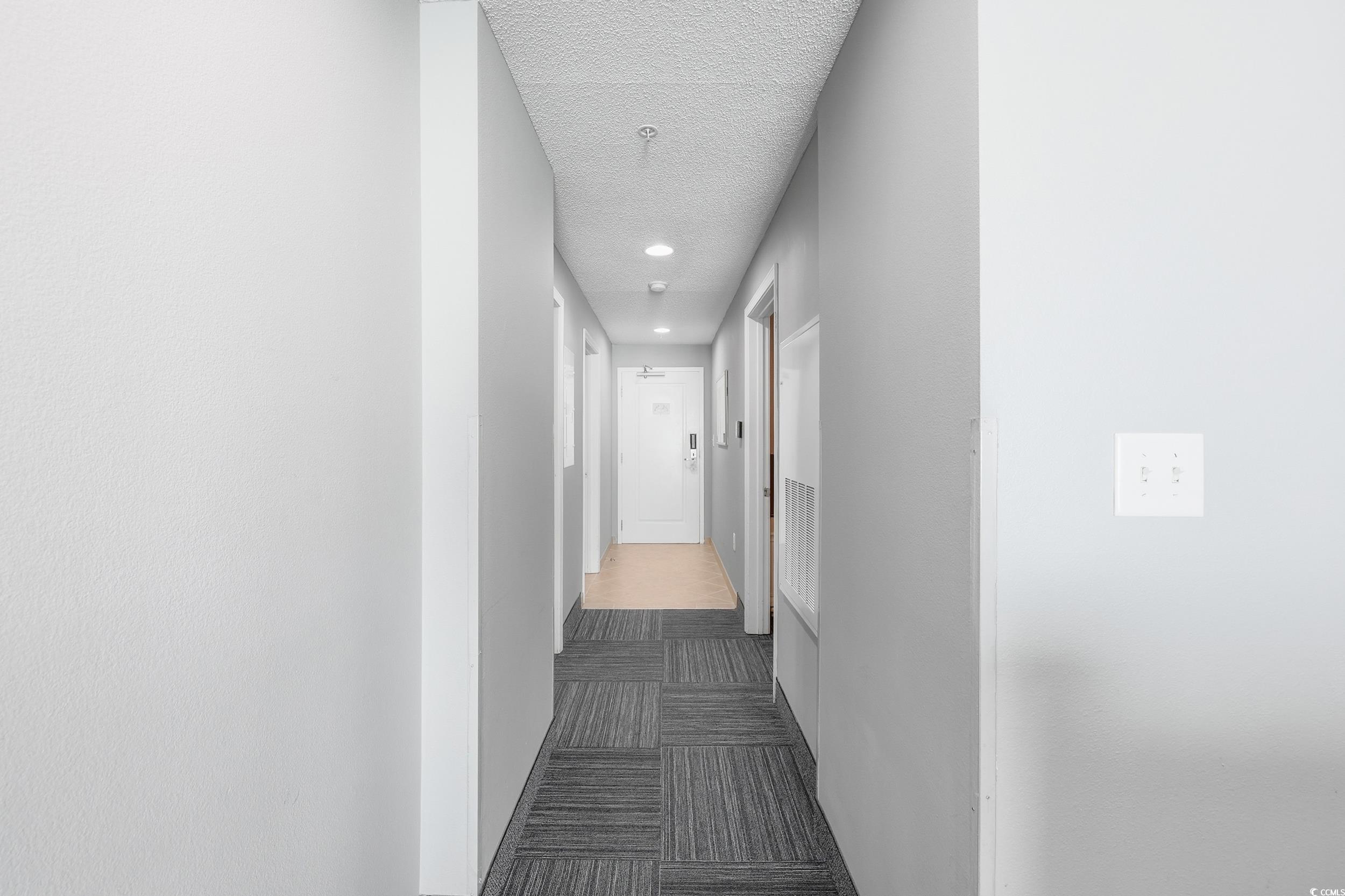300 North Ocean Boulevard, Unit 1608 North Myrtle Beach, SC 29582 - Photo 7 of 30 Corridor with dark carpet, a textured ceiling, and recessed lighting