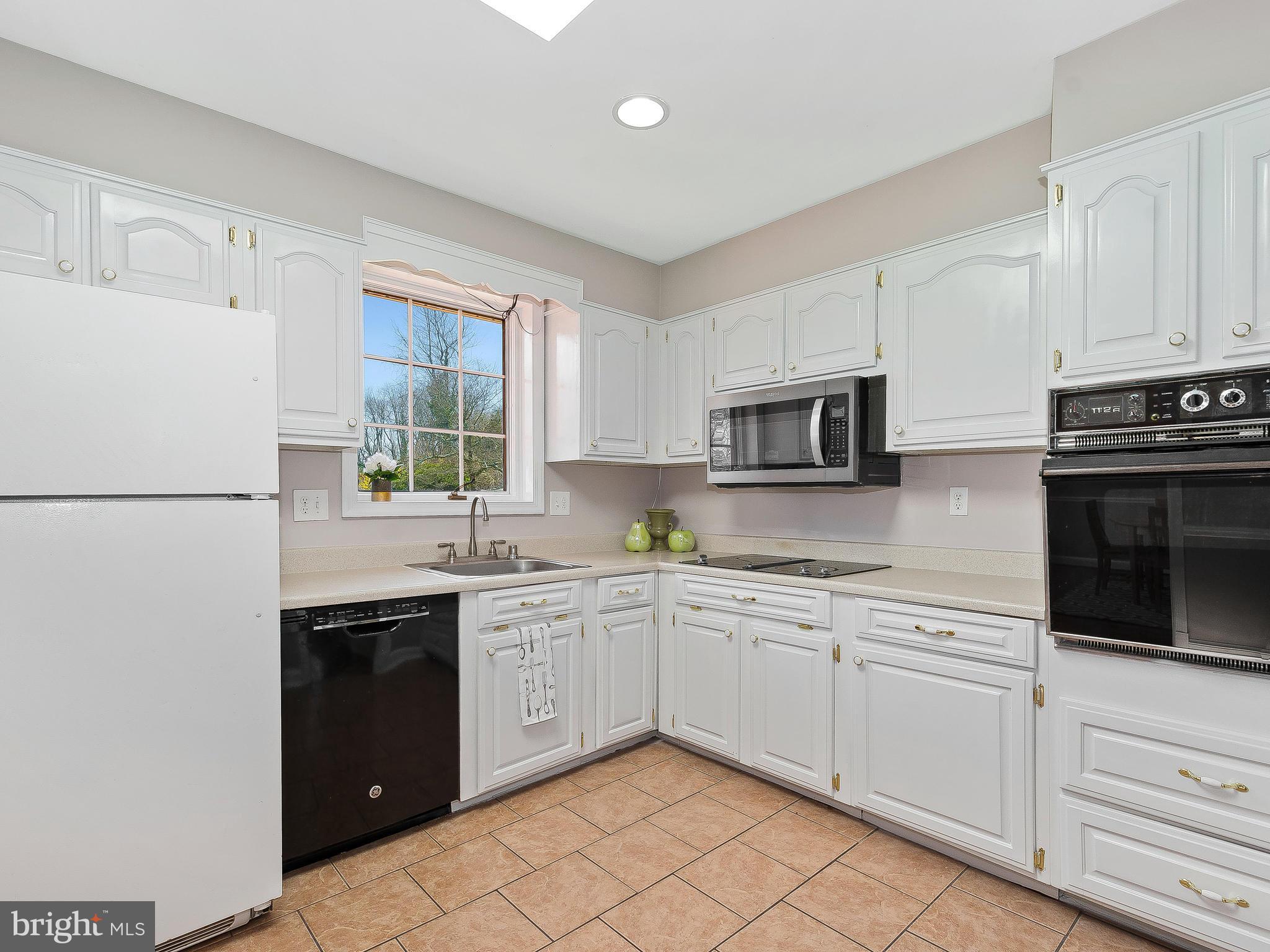 13245 Glenhill Road Silver Spring, MD 20904 - Photo 11 of 30 a kitchen with stainless steel appliances granite countertop white cabinets sink and a window