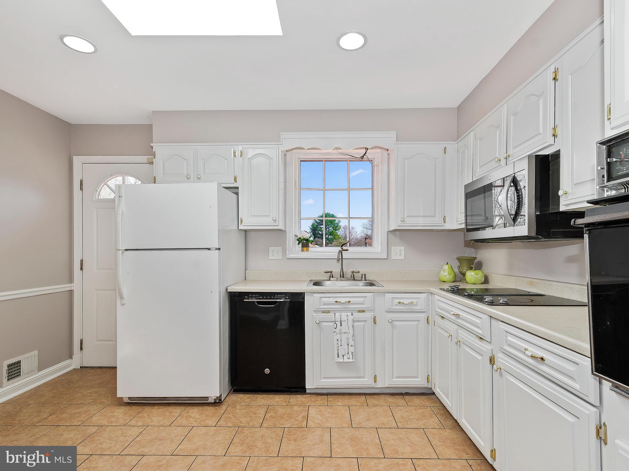 13245 Glenhill Road Silver Spring, MD 20904 - Photo 12 of 30 a kitchen with stainless steel appliances a refrigerator sink and white cabinets