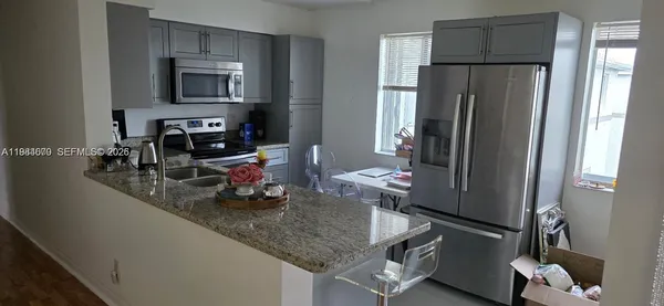 a kitchen with stainless steel appliances granite countertop a refrigerator and a stove top oven