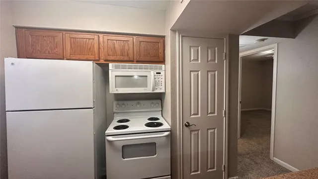 a white refrigerator freezer and a stove sitting inside of a kitchen