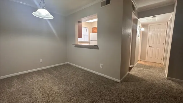 an empty room with a fan & a window