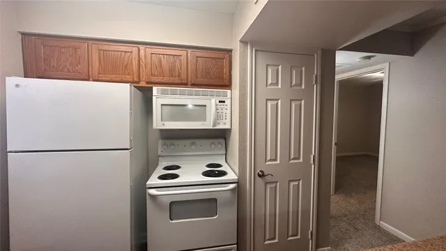 a white refrigerator freezer and a stove sitting inside of a kitchen