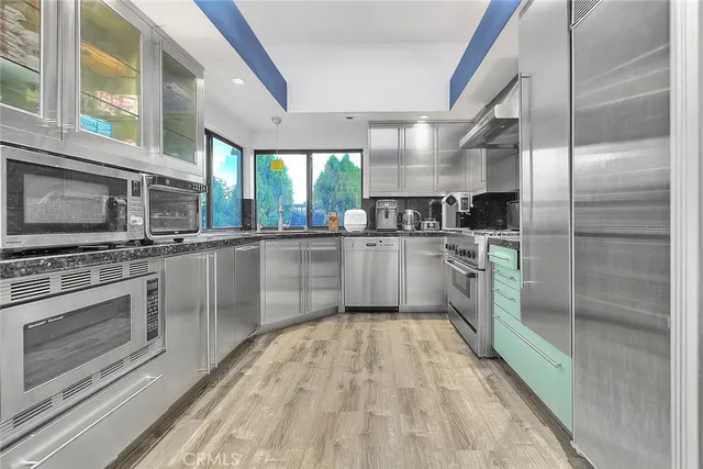 a kitchen with stainless steel appliances granite countertop a stove and a microwave