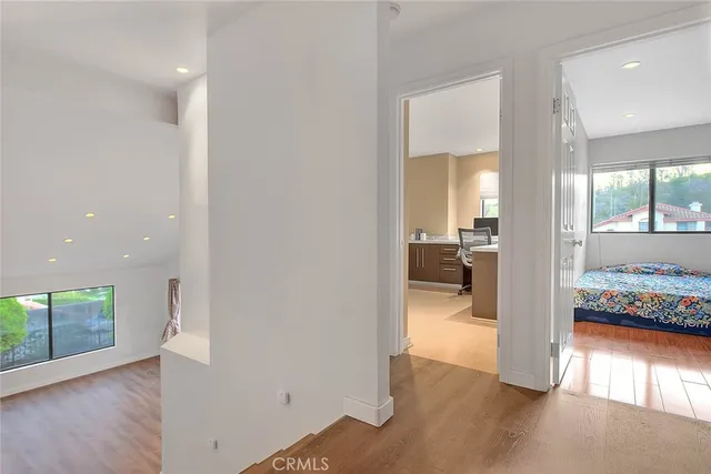 a living room with furniture large window and wooden floor