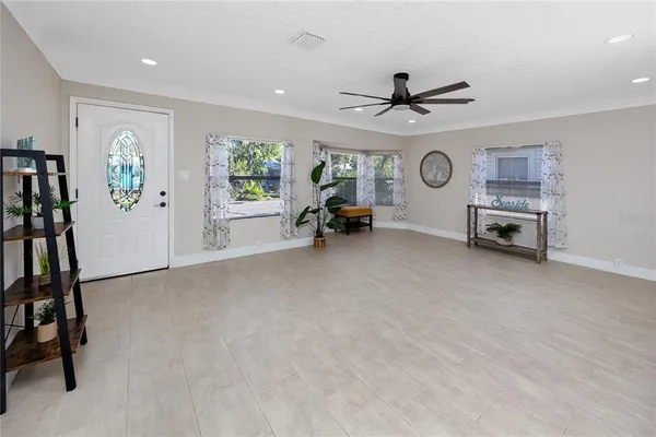 a view of a livingroom with furniture a ceiling fan and window