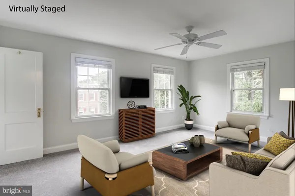 a living room with furniture a flat screen tv and a window