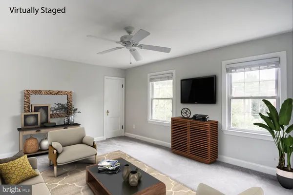 a living room with furniture a flat screen tv and a window