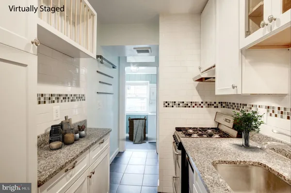 a kitchen with granite countertop a sink stove and cabinets