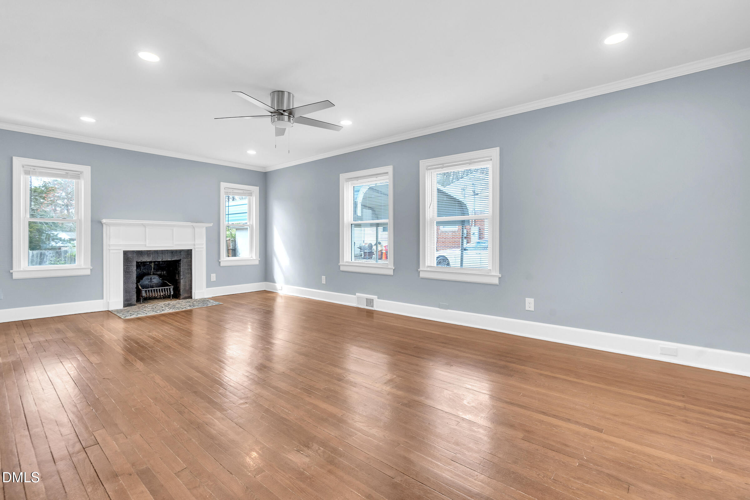 134 Nelson Street Durham, NC 27707 - Photo 7 of 25 an empty room with wooden floor fireplace and windows