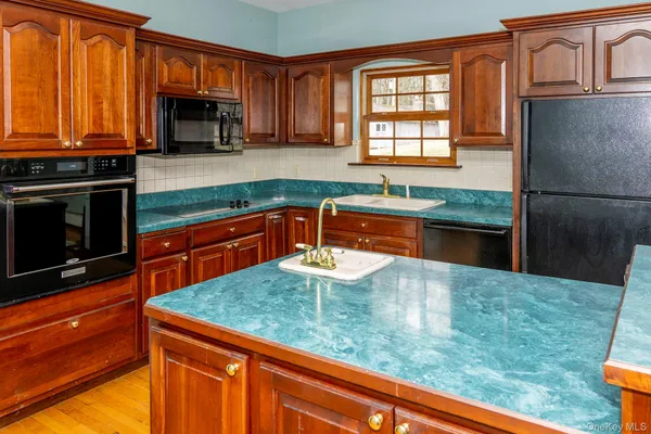 a kitchen with granite countertop a stove a sink and a microwave