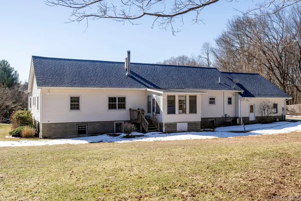a view of house with yard and outdoor seating