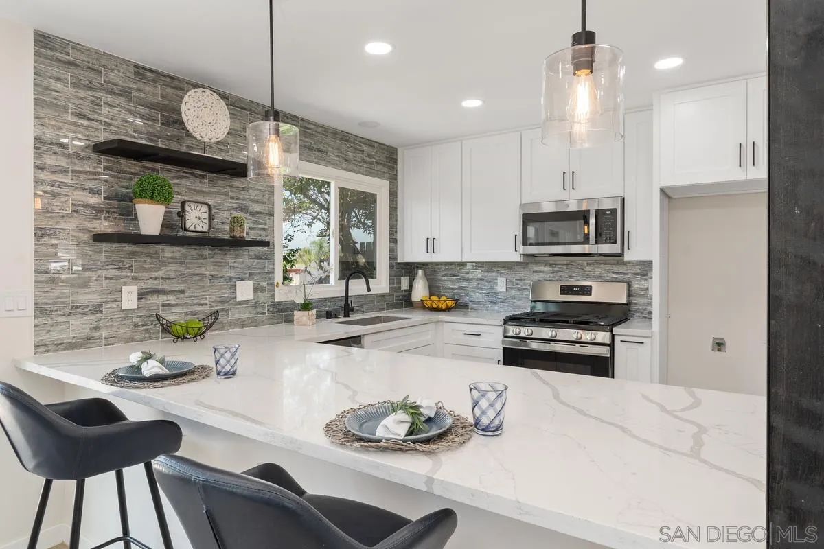 9257 Ruffin Road Santee, CA 92071 - Photo 12 of 28 a kitchen with stainless steel appliances a stove a sink a microwave a refrigerator and cabinets