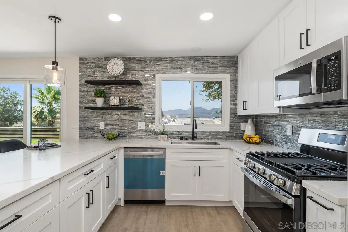 9257 Ruffin Road Santee, CA 92071 - Photo 13 of 28 a kitchen with stainless steel appliances granite countertop a sink a stove and a wooden floors