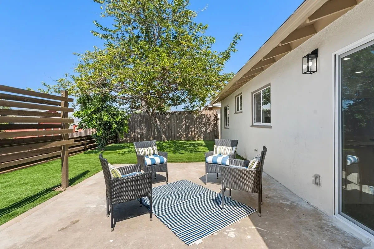 9257 Ruffin Road Santee, CA 92071 - Photo 17 of 28 a view of a patio with a dining table and chairs with a small yard