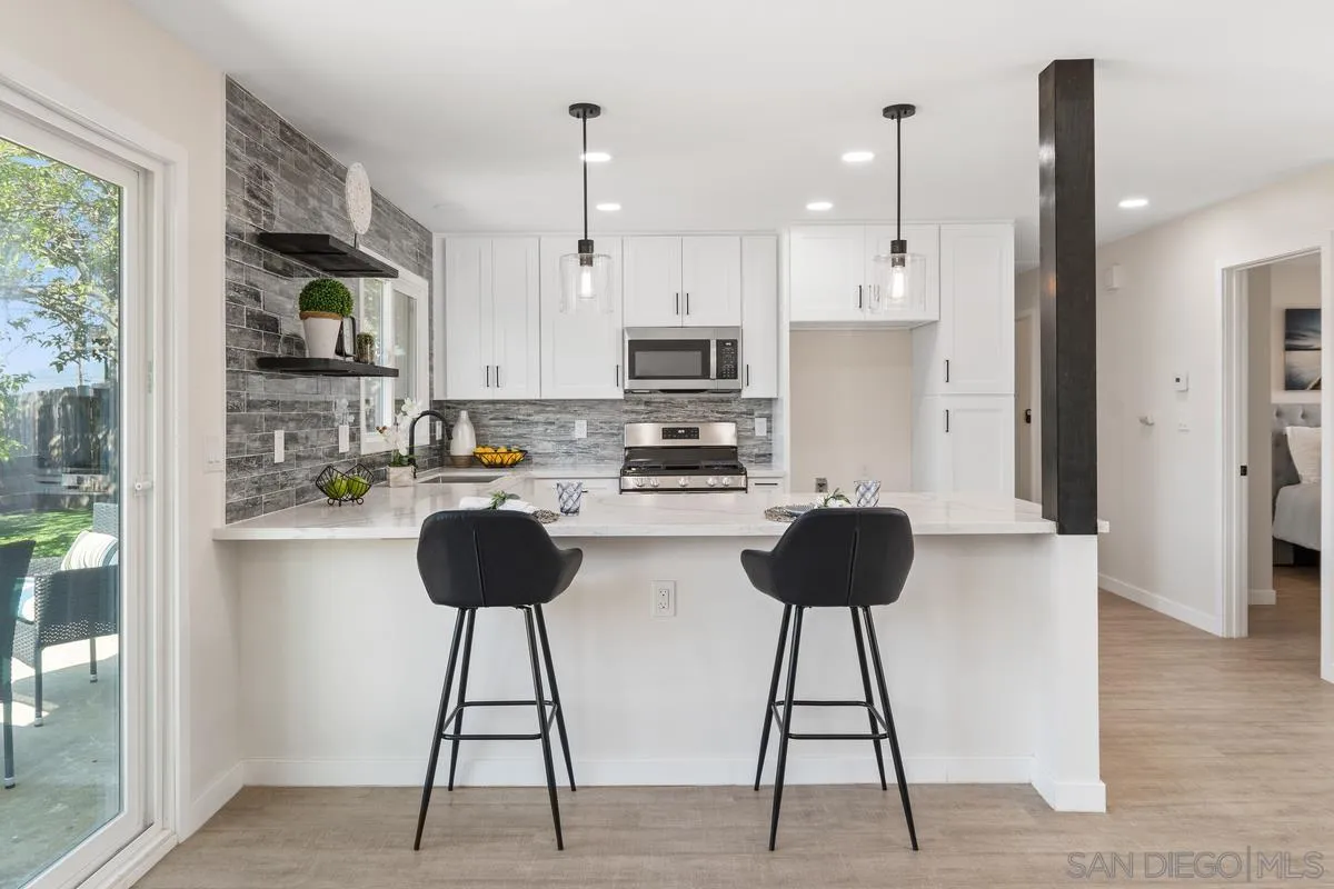 9257 Ruffin Road Santee, CA 92071 - Photo 4 of 28 a kitchen with stainless steel appliances a stove a refrigerator a sink a dining table and chairs
