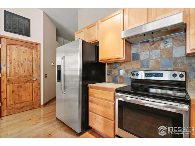 a kitchen with stainless steel appliances granite countertop a refrigerator stove and cabinets