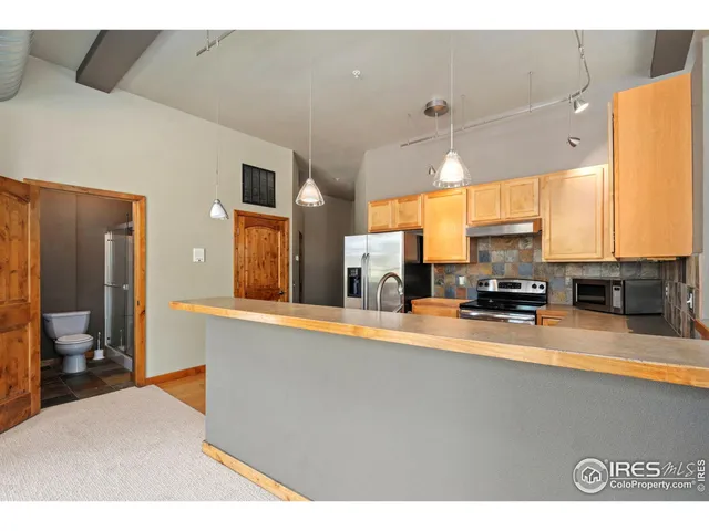 a living room with stainless steel appliances kitchen island granite countertop furniture and a large window