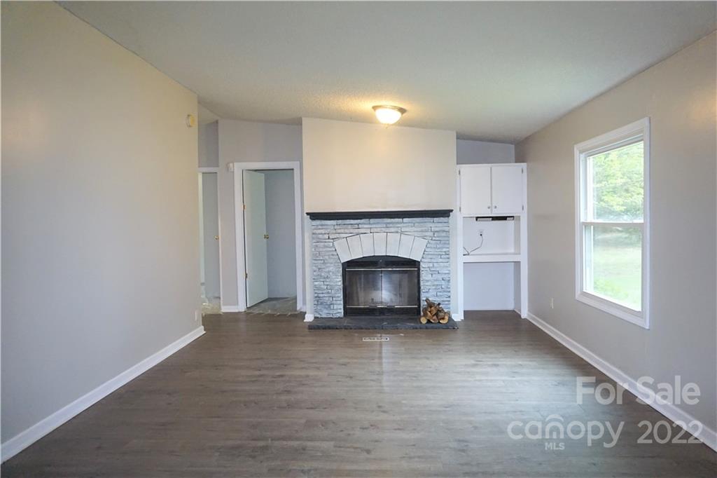 1291 Hines Road Clover, SC 29710 - Photo 7 of 26 a view of a livingroom with a fireplace wooden floor and windows