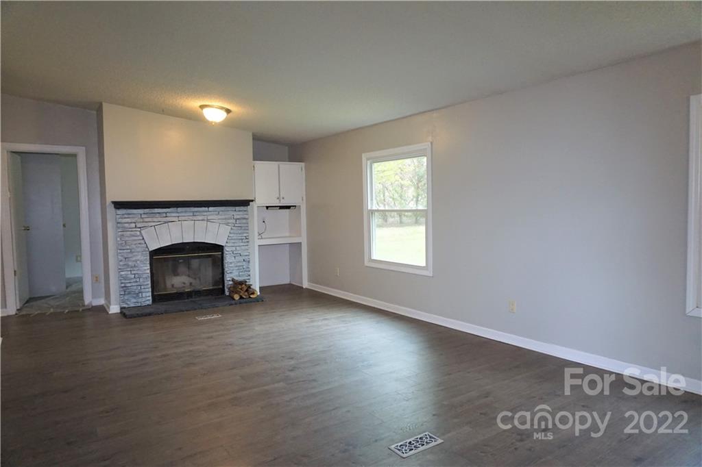 1291 Hines Road Clover, SC 29710 - Photo 10 of 26 an empty room with windows a fireplace and wooden floor
