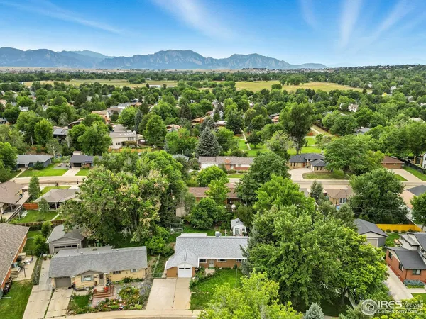 an aerial view of residential houses with outdoor space and trees