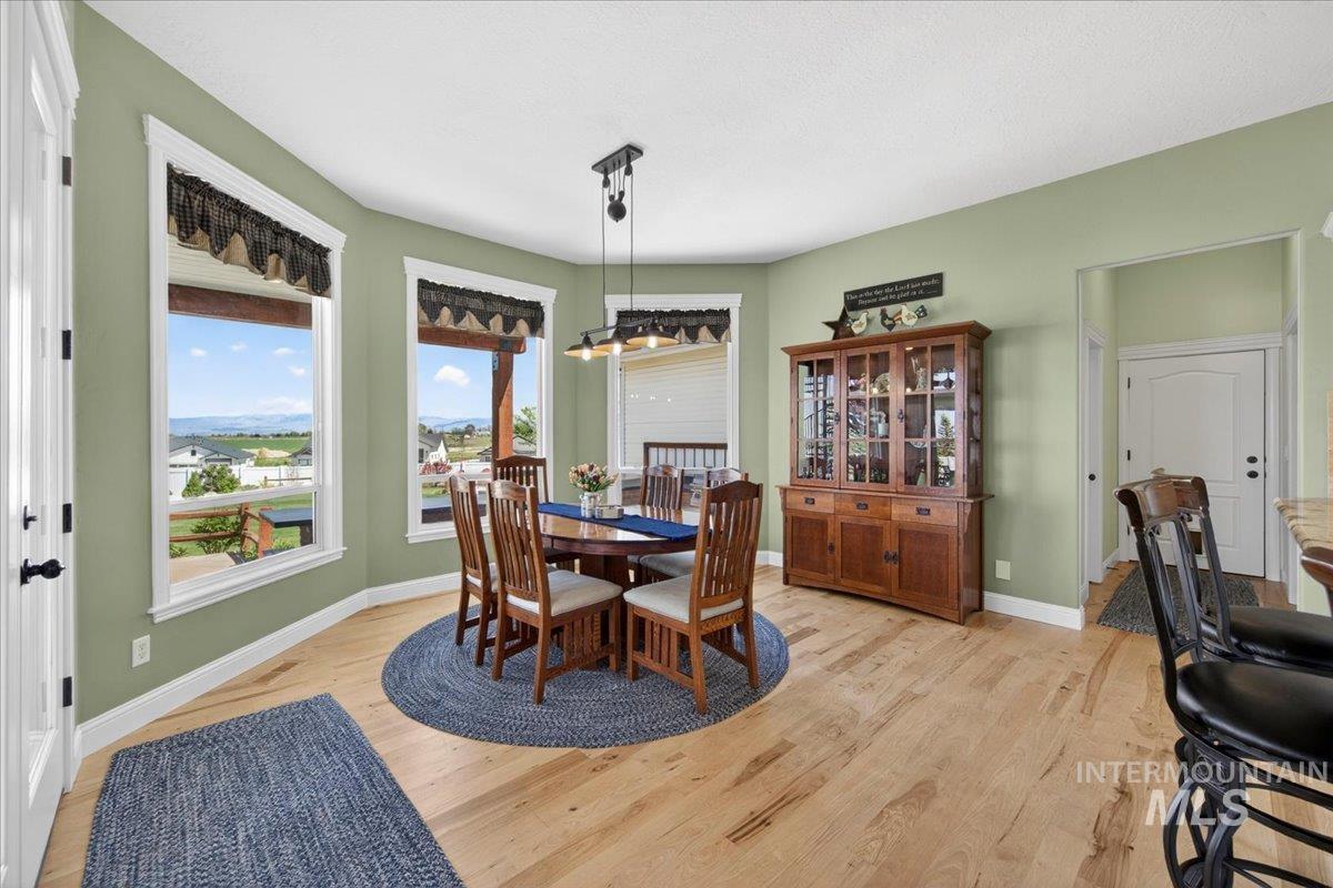 414 East Shafer View Drive Meridian, ID 83642 - Photo 9 of 50 Informal Dining Space has the most incredible VIEWS! Room for the Hutch, all on gorgeous, recently installed, Natural Hickory hardwood flooring and a glass paneled door to the covered back patio!