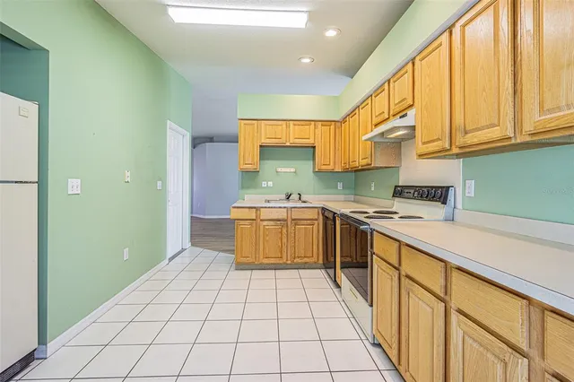 a kitchen with a sink a stove top oven and cabinets