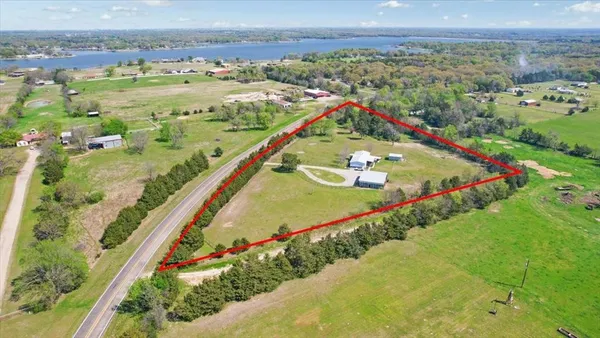 an aerial view of a residential houses with outdoor space and river