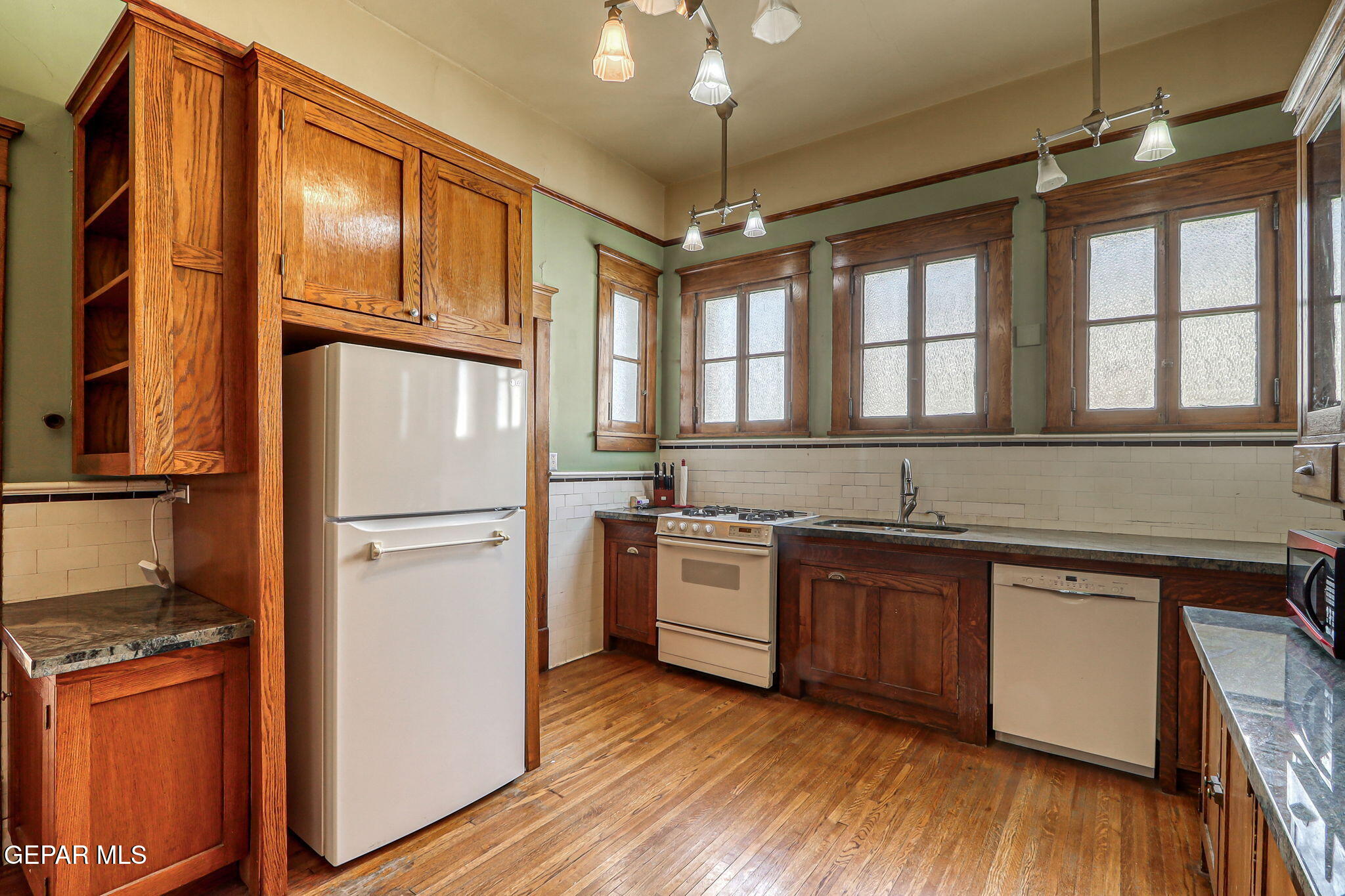 525 Corto Way El Paso, TX 79902 - Photo 23 of 98 a kitchen with stainless steel appliances granite countertop a refrigerator a sink dishwasher a stove and white countertops with wooden floor