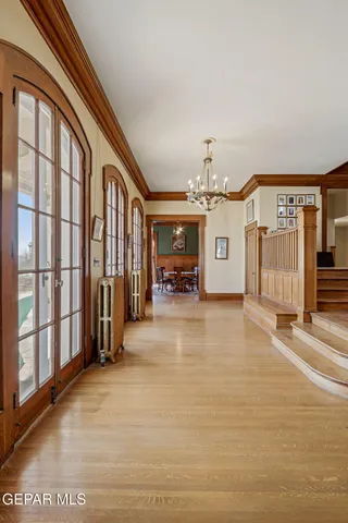 a dining room with furniture wooden floor a rug and a chandelier