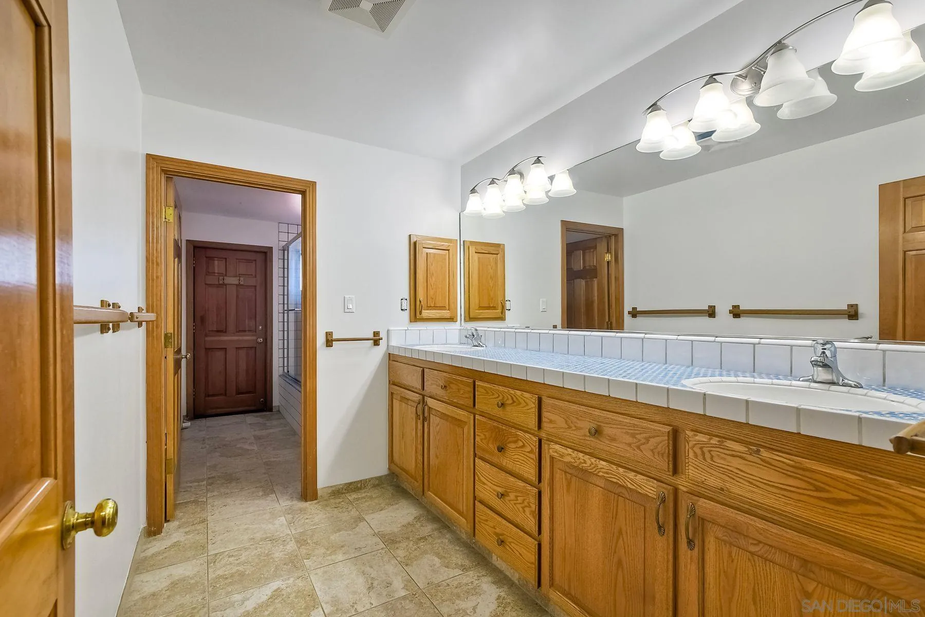 2511 Vía Rancheros Fallbrook, CA 92028 - Photo 38 of 59 a bathroom with a double vanity sink and a mirror