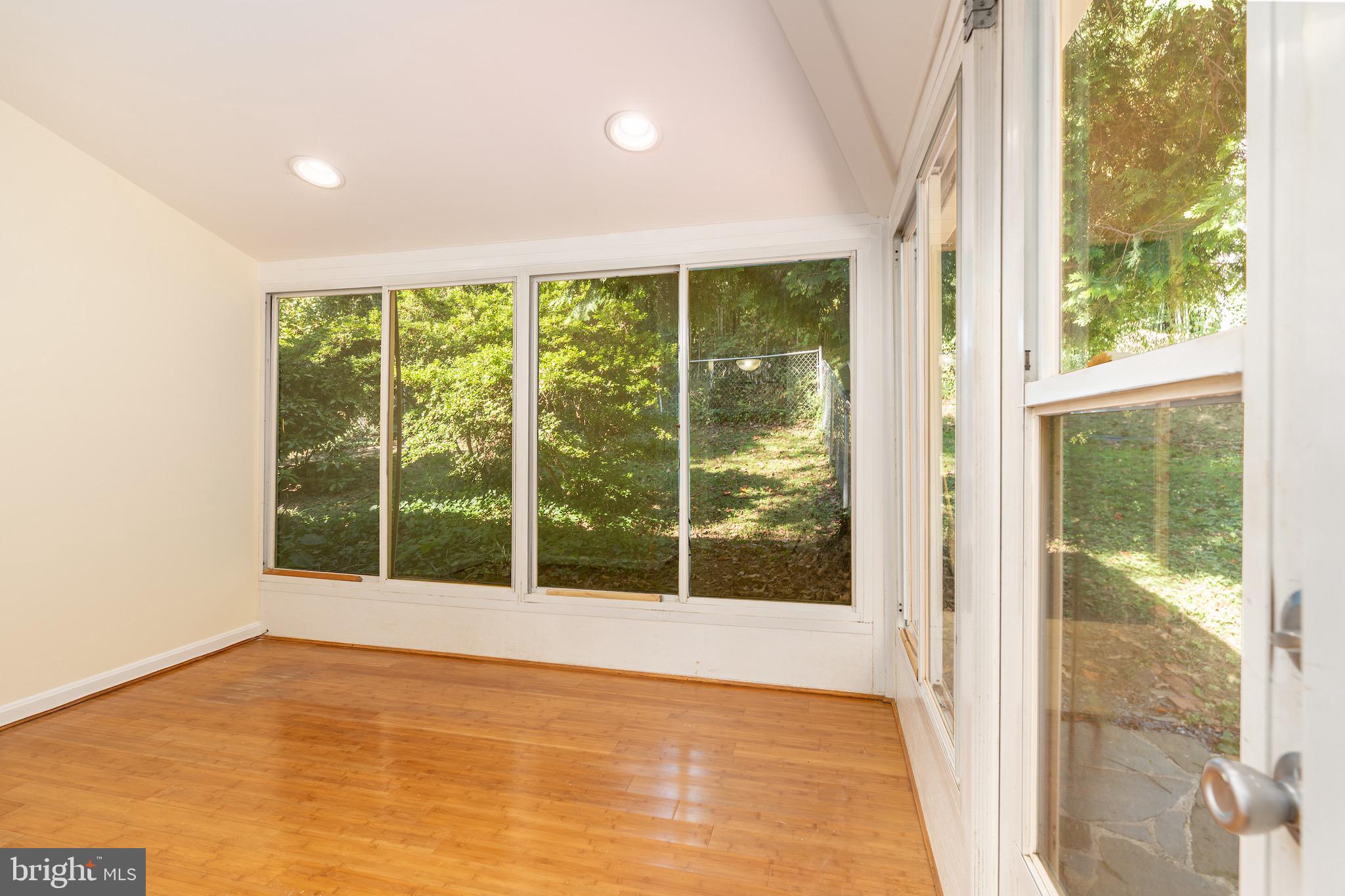 6221 Walhonding Road Bethesda, MD 20816 - Photo 17 of 51 a view of an empty room with wooden floor and a window