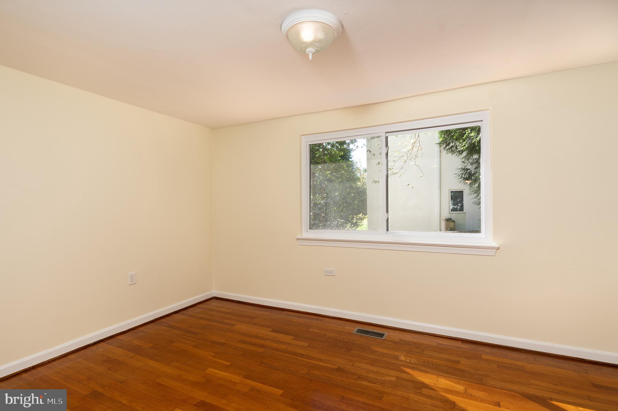 6221 Walhonding Road Bethesda, MD 20816 - Photo 27 of 51 an empty room with wooden floor and windows