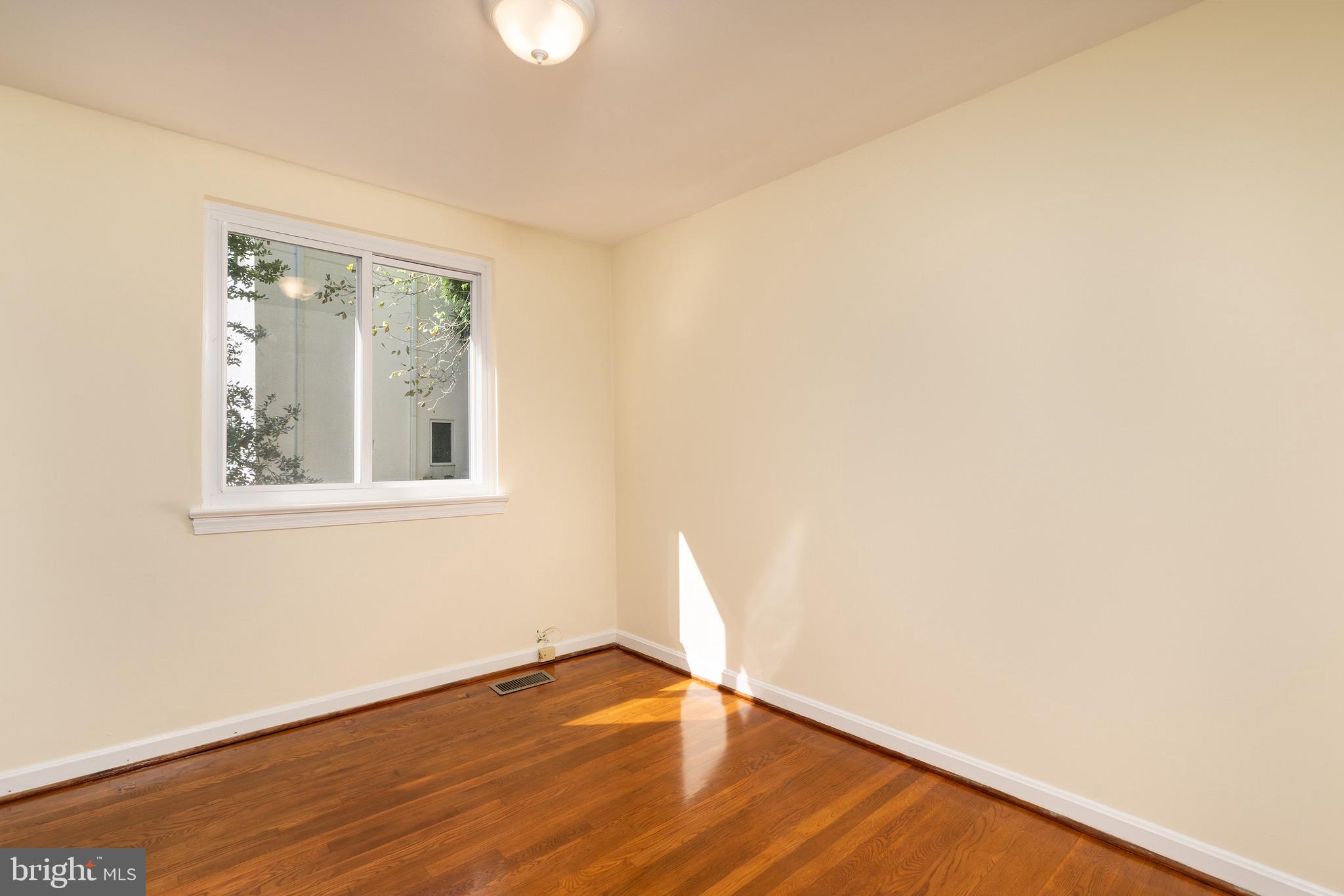 6221 Walhonding Road Bethesda, MD 20816 - Photo 31 of 51 a view of an empty room with wooden floor and a window