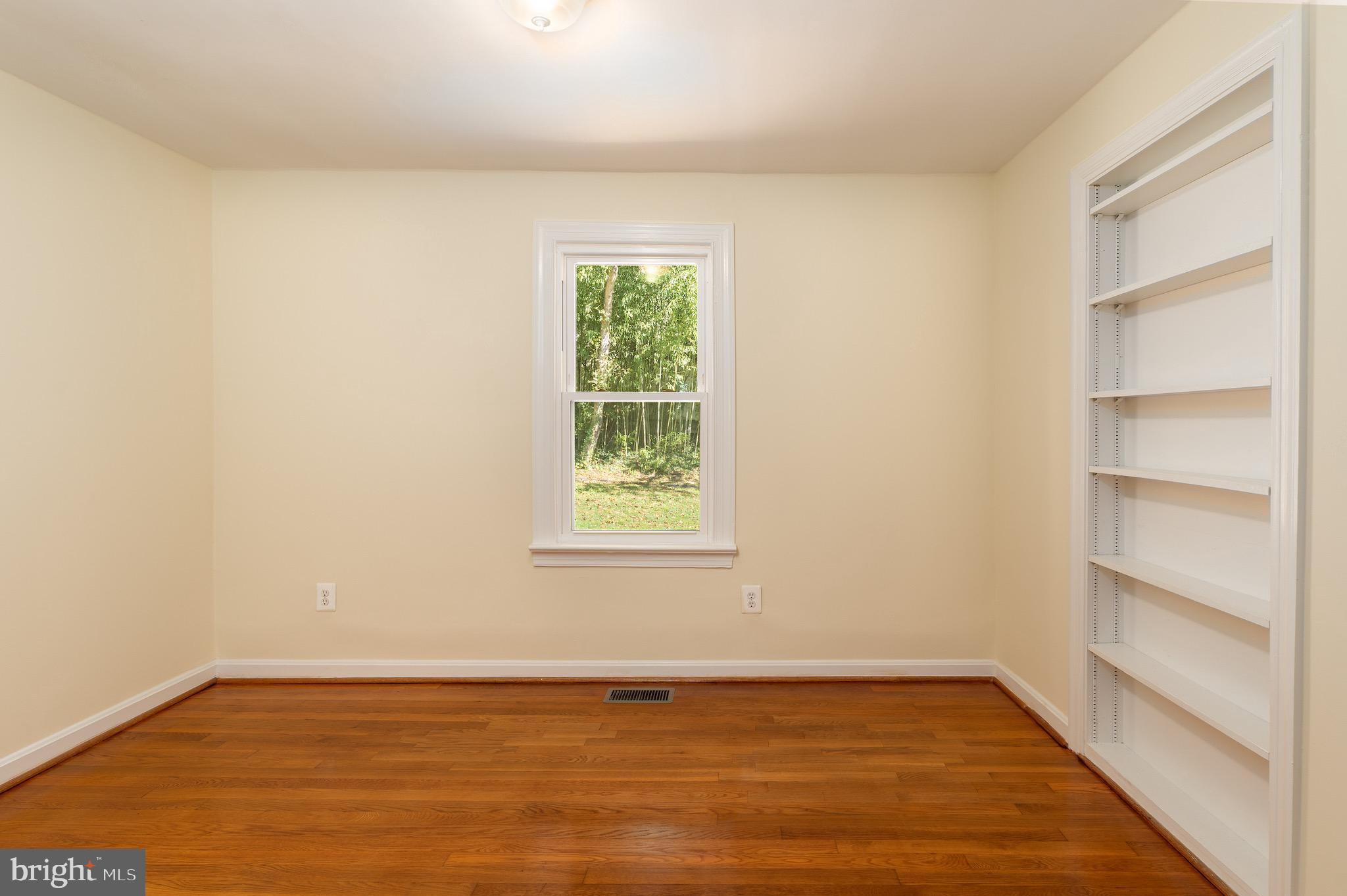 6221 Walhonding Road Bethesda, MD 20816 - Photo 33 of 51 a view of an empty room with wooden floor and a window