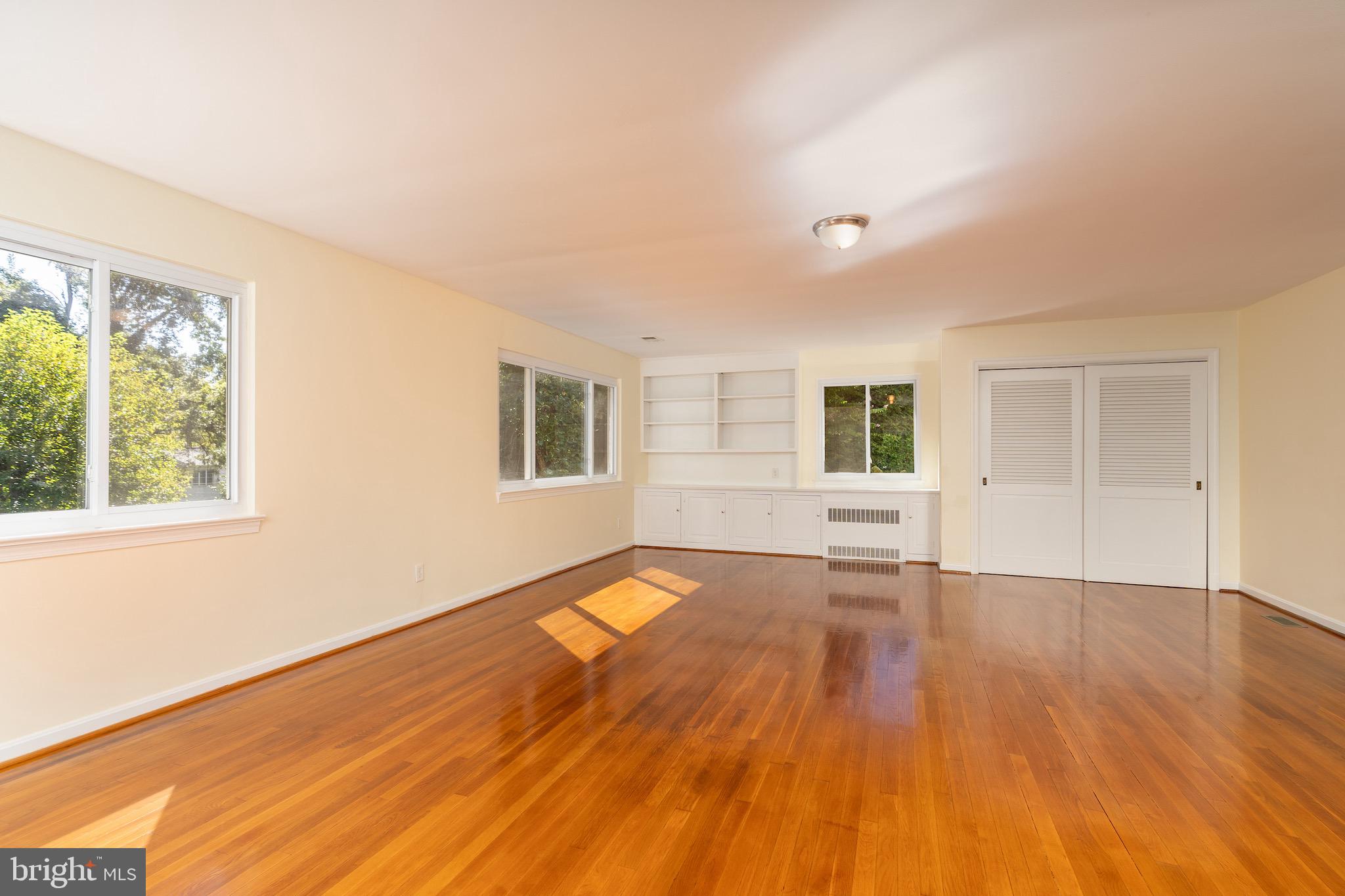 6221 Walhonding Road Bethesda, MD 20816 - Photo 10 of 51 a view of an empty room with wooden floor and a window
