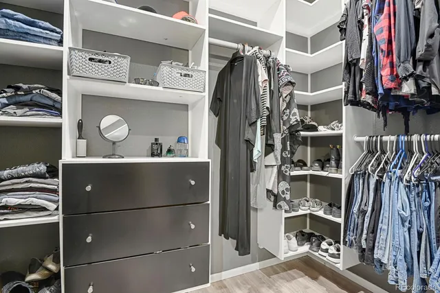 a view of walk in closet with clothes and shoes